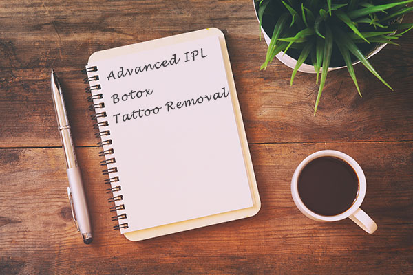 Picture of a clipboard next to a cup of coffee with a list of beauty treatments written on it